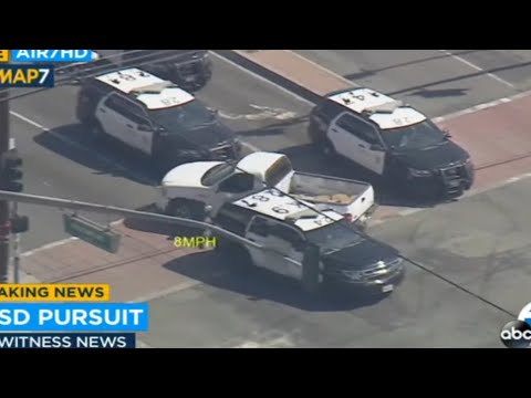 Police cars surround vehicle in pursuit scene.