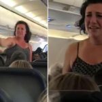 Passenger standing and speaking on airplane.