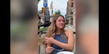 Woman dining outdoors, flipping hair