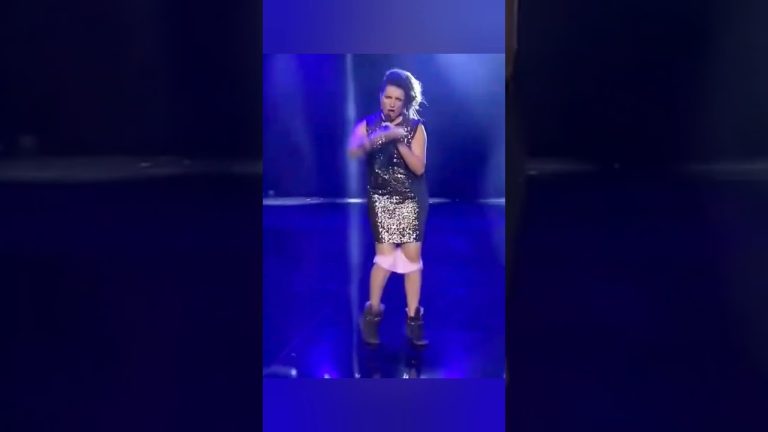 Woman performing on stage under blue lights