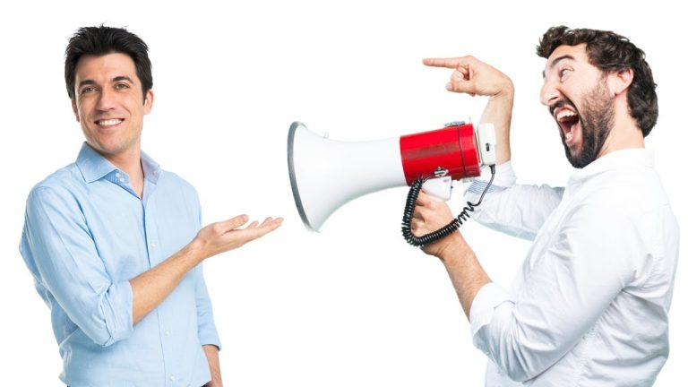 Man smiling at another man with megaphone