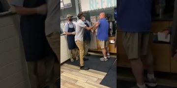 Workers assist customer at service counter