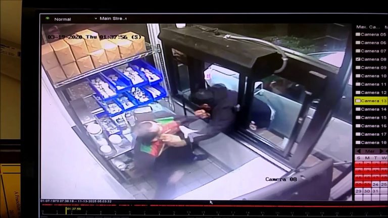 Drive-thru employee hands item to car passenger