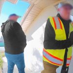 Two men at door, one in safety vest.