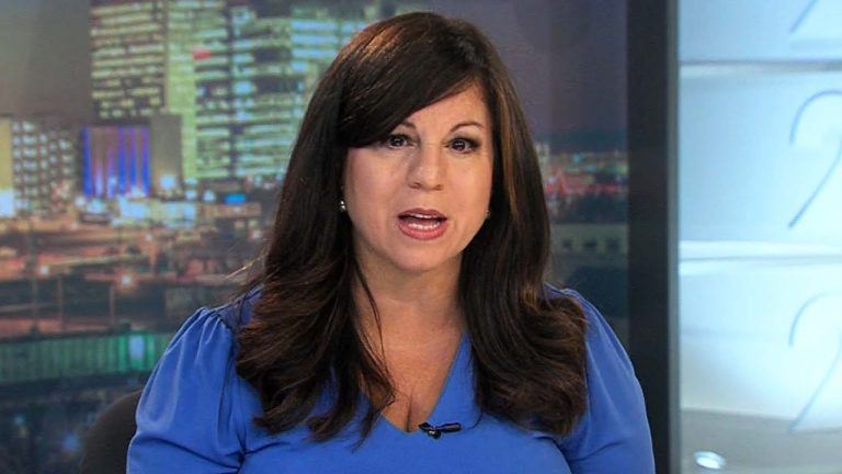 News anchor delivering report in studio.