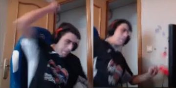 Gamer reacts angrily while playing video game.