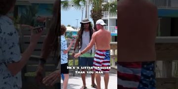 Three men talking on boardwalk, palm trees background.