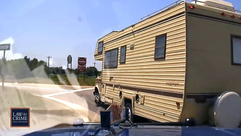 RV on highway intersection captured by dashcam.