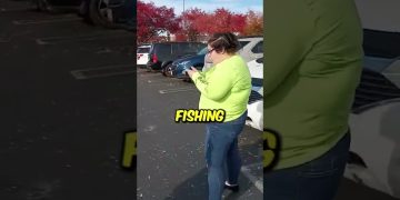 Person in parking lot with phone, fishing shirt