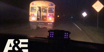 Police chase school bus at night on highway.