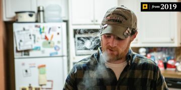 Man in kitchen wearing veteran cap, 2019.