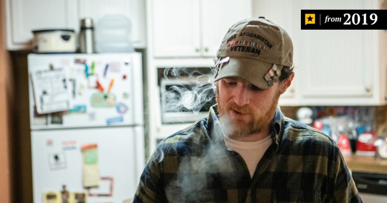Man in kitchen wearing veteran cap, 2019.