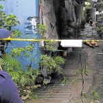 Crime scene with police caution tape and alleyway.