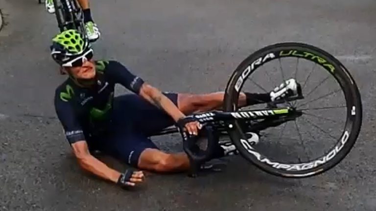 Cyclist falls during race, lying on the road.