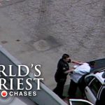 Police arrest person on top of patrol car