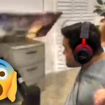 Man reacts with shock near computer screen.