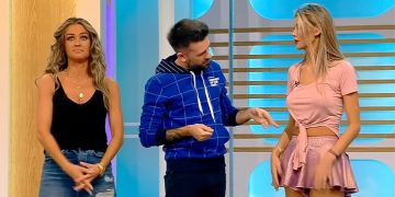 Three people talking on a TV show set.
