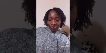 Person in cozy sweater relaxing indoors.
