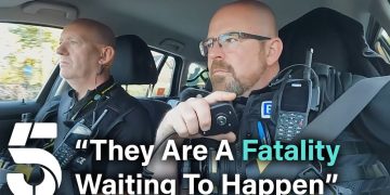 Police officers in car with communication gear.