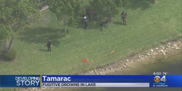 Police by lake in Tamarac incident scene.