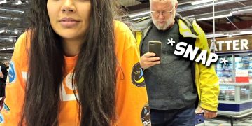Woman shopping, man taking photo in store.