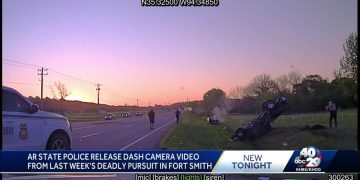 Police dashcam captures flipped car at sunset roadside.