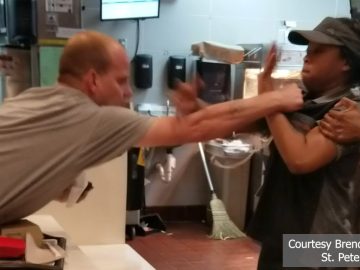 Fast-food worker defends against aggressive customer.
