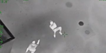 Infrared image of two people on the ground.