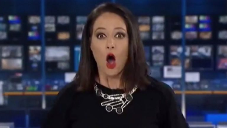 Surprised woman in TV studio, wide-eyed expression.