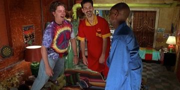 Three friends laughing in a colorful room setting.