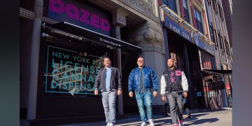 Three men walking past Dazed storefront in New York.