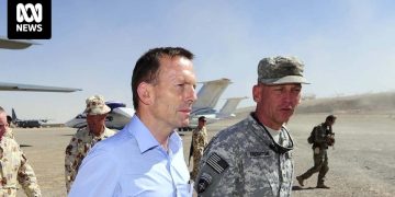 Military personnel and aircraft on a desert airstrip.
