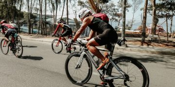 Cyclists racing on sunny road.
