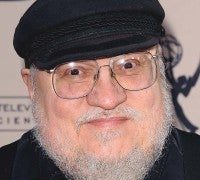 Person wearing glasses and a hat, smiling.