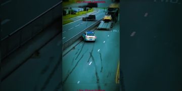 Police car on highway near vehicle carrier