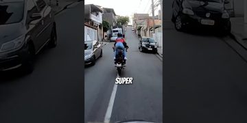 Motorcyclist performing stunt on urban street.