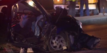 Car crash scene at night with debris visible.