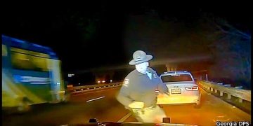 Police officer on roadside near car at night