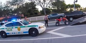 Police car at traffic stop with a quad bike.