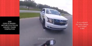 Motorcycle evading police SUV on road.