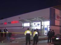 Police investigate Rite Aid pharmacy at night.
