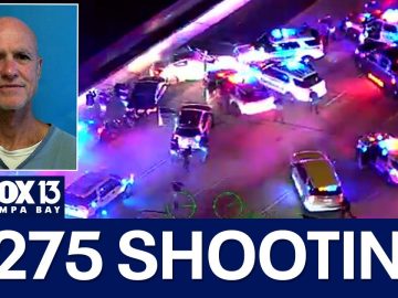 I-275 shooting scene with police vehicles and reporter.