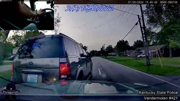 Police car dashcam footage of vehicle on suburban road.