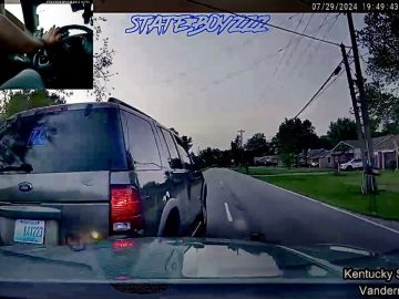 Police car dashcam footage of vehicle on suburban road.