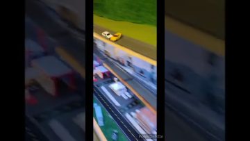 Toy cars racing on miniature track.