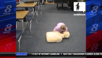 Toddler practicing on CPR dummy in classroom