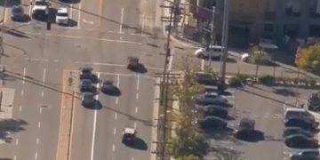 Aerial view of busy intersection and parked cars.