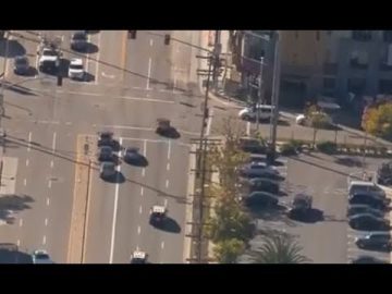 Aerial view of busy intersection and parked cars.