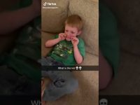 Child playfully holding cheeks on couch