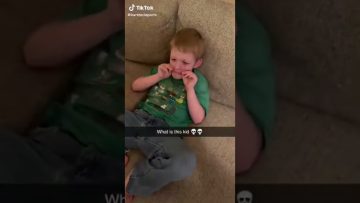 Child playfully holding cheeks on couch